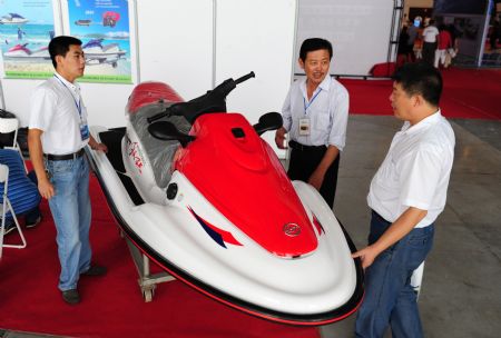 An exhibitor introduces his jet-skier to the visitors at the 2009 Sino-South Korea Shipping Industry Fair in Yantai, north China's Shandong province, September 4, 2009. 