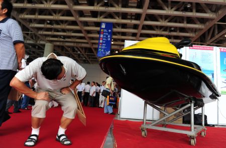 A visitor takes a close look at a jet-skier at the 2009 Sino-South Korea Shipping Industry Fair in Yantai, north China's Shandong Province, September 4, 2009. 