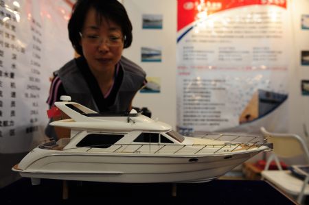 A visitor watches a yacht model at the 2009 Sino-South Korea Shipping Industry Fair in Yantai, north China's Shandong province, September 4, 2009. 