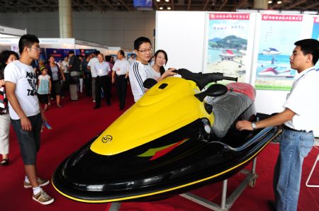 An exhibitor introduces his jet-skier to visitors at the 2009 Sino-South Korea Shipping Industry Fair in Yantai, north China's Shandong province, September 4, 2009. 