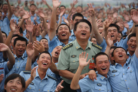 Photo taken on July 4, 2009 shows Chinese soldiers watch the parachuting performance during a break of parade training in Beijing, capital of China. 