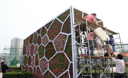 Gardeners are busy with setting up a giant parterre in the shape of the National Aquatics Center popularly known as Water Cube, at the intersection of business downtown of Dongdan, in Beijing, September 5, 2009.