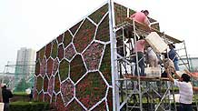 Gardeners are busy with setting up a giant parterre in the shape of the National Aquatics Center popularly known as Water Cube, at the intersection of business downtown of Dongdan, in Beijing, September 5, 2009.