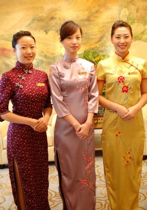 Staffs of Dalian Shangrila Hotel present five designs of cheongsams at the hotel in Dalian, northeast China&apos;s Liaoning Province, September 7, 2009. 