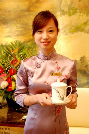 A staff of Dalian Shangrila Hotel presents a design of cheongsam at the hotel in Dalian, northeast China&apos;s Liaoning Province, September 7, 2009.