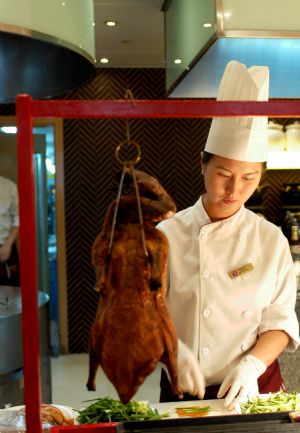 A chef prepares a dish of Beijing Roasted Duck at Dalian Shangrila Hotel in Dalian, northeast China's Liaoning Province, September 7, 2009. As an offical reception hotel of the Annual Meeting of the New Champions 2009, or Summer Davos, Dalian Shangrila Hotel will supply a lot of famous Chinese foods for foreign guests to enjoy the Chinese taste. Over 1,300 pariticipants from 86 countries and regions will attend the meeting to be held from September 10 to 12. 