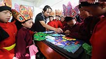 A teacher of the Naxi ethnic group teaches her students how to draw traditional paintings of Dongba culture at a primary school in Lijiang, southwest China's Yunnan Province, September 4, 2009.