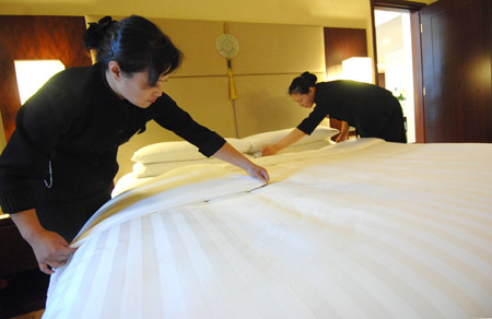 Waitresses prepare the bedroom for Klaus Schwab, founder and chairman of the World Economic Forum (WEF), at the Shangrila Hotel in Dalian, northeast China's Liaoning Province, September 7, 2009. 