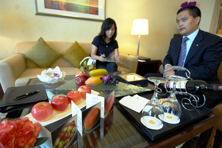 Staff members of the Shangrila Hotel discuss the preparation of fresh fruites at the suite-room for Klaus Schwab, founder and chairman of the World Economic Forum (WEF), at the Shangrila Hotel in Dalian, northeast China's Liaoning Province, September 7, 2009.