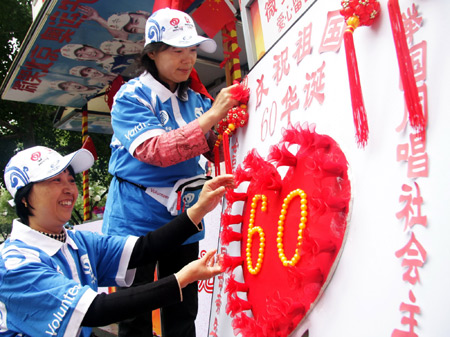 Volunteers decorate the service station for the National Day celebrations on a street in Beijing, China, September 7, 2009. A total of 35,000 city volunteers went to work in succession in 227 service stations as October 1, China's National Day, approaches. Their voluntary services including information, translation, first-aid, and etc. will last until October 8.