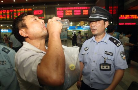 A passenger receives security check to his drinks that would be brought aboard the coaches at the Hangzhou Railway Station, in east China's Zhejiang Province, September 8, 2009.