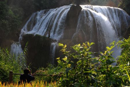 Photographers shoots the Sanla waterfalls in Guangnan County, Zhuang and Miao Autonomous Prefecture of Wenshan Autonomous Prefecture, southwest China's Yunnan Province, September 6, 2009. 
