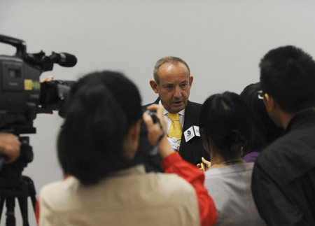 Yvo De Boer (C, back), Executive Secretary of United Nations Framework Convention on Climate Change (UNFCCC), is crowded by journalists after a press conference on the key role of Copenhagen Deal in moving towards a green economy at the Annual Meeting of the New Champions 2009 in Dalian, northeast China's Liaoning Province, Sept. 11, 2009. (Xinhua/Xu Liang)