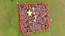 A super phalanx of the national flag of the People's Republic of China (PRC) formed by a group of juveniles strikes the limelight during an overall aerial photo-taking activity for the Aerial View of New Yangzhou in celebration of the 60th anniversary of the PRC's founding.