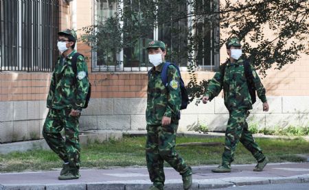 Masked students walk at Heilongjiang University in Harbin, capital of northeast China's Heilongjiang Province, September 14, 2009. 