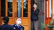 A masked student (R) stands at the entrance to Wing Building 8 of Zone B at Heilongjiang University in Harbin, capital of northeast China's Heilongjiang Province, September 14, 2009.