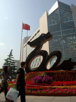 People walk past a huge parterre in Beijing, capital of China, September 14, 2009. More than 40 million flowers will decorate the city for the celebration of the 60th anniversary of the founding of the People's Republic of China, which falls on October 1.