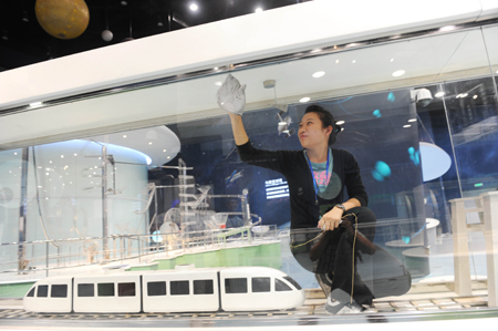 A staff worker wipes the window at the new hall of China Science and Technology Museum in Beijing, China, September 13, 2009. The new hall of China Science and Technology Museum which located in the Olympic Park will open to the public on September 20.