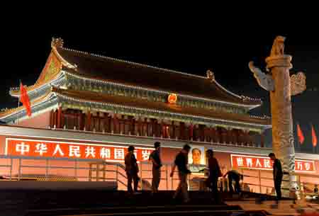 People are seen in front of the illuminated Tian'anmen Gate Tower in Beijing, capital of China, September 14, 2009. A total of 21 lighting installations in the city have been fixed or renovated for the celebration of the 60th anniversary of the founding of the People's Republic of China, which falls on October 1.