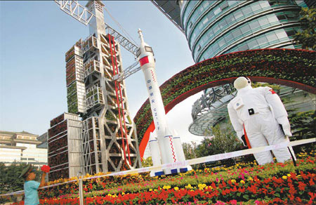 A child plays nearby the aerospace science and technology flower parterre in Beijing yesterday.