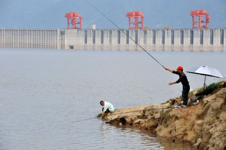 Two locals go fishing near the Three Gorges reservoir in Yichang, a city of central China's Hubei Province, September 15, 2009. The operation to raise the water level of the Three Gorges reservoir to 175 meters began early Tuesday. 