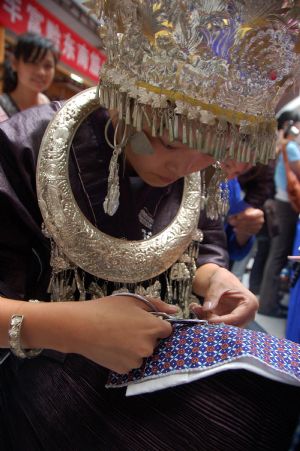 A competitor makes embroidery during a traditional handicraft competition in Kaili, southwest China's Guizhou Province, September 15, 2009. More than 100 craftsmen took part in the competition to showcase their skills of making embroidery and silver wares etc.