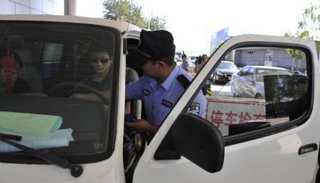  A policeman checks a vehicle at a checkpoint in Beijing, capital of China, September 15, 2009, in a move to secure the celebrations for the 60th anniversary of the founding of the People's Republic of China, whose National Day falls on October 1. 