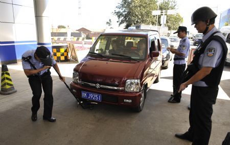 Policemen check a car at a checkpoint in Beijing, capital of China, September 15, 2009, in a move to secure the celebrations for the 60th anniversary of the founding of the People's Republic of China, whose National Day falls on October 1.