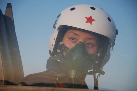 A female pilot in full flight suit sits in a jet at an airport in Beijing, China in this photo taken on July 14, 2009. China's first batch of 16 female combat pilots will perform a flyover above Tian'anmen Square at the National Day Parade on October 1. 