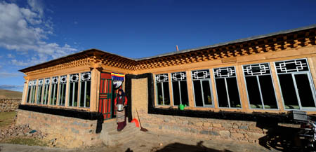 A woman walks out of herdsman Cering Tonzhub&apos;s new house in Bangoin County, southwest China&apos;s Tibet Autonomous Region, September 15, 2009.