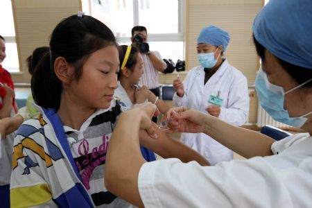 Pupils get flu vaccination shots at Hepingli No.9 Primary School in Dongcheng District of Beijing, capital of China, September 16, 2009.