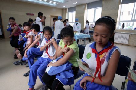 Pupils are seen after getting flu vaccination shots at Hepingli No.9 Primary School in Dongcheng District of Beijing, capital of China, September 16, 2009.