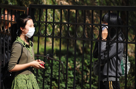 Two students talk at the gate of Heilongjiang University in Harbin, capital of northeast China's Heilongjiang Province, September 16, 2009.