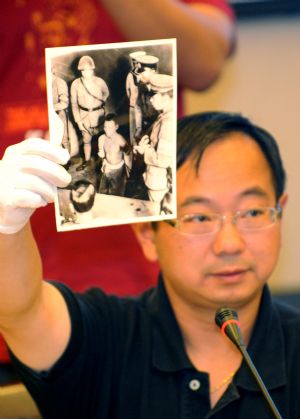 Lu Zhaoning, a Chinese-American, shows a photo taken in 1937 by Japanese invaders during the World War II in Nanjing, provincial capital of east China's Jiangsu Province, September 19, 2009. Lu Zhaoning, a Chinese-American who was born in Nanjing, donated 71 pieces of precious records to the Memorial Hall of the Victims of the Nanjing Massacre on Saturday.