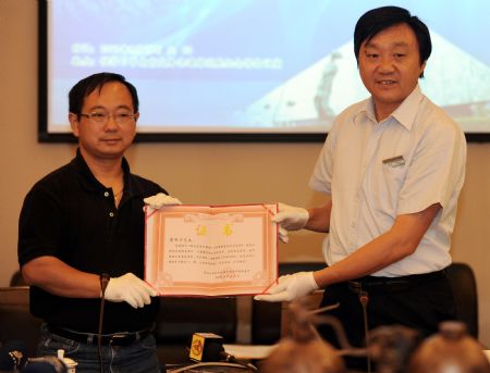 Zhu Chengshan (R), head of Nanjing's Memorial Hall of the Victims of the Nanjing Massacre, presents a certificate of donation to Lu Zhaoning, a Chinese-American, in Nanjing, provincial capital of east China's Jiangsu Province, September 19, 2009.