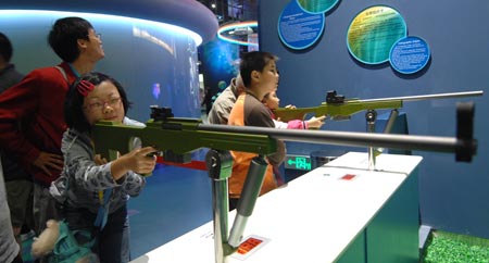 Children experience the shooting theory in the new China Science and Technology Museum in Beijing, capital of China, Sept. 20, 2009. The Hi-tech and newly-built museum covering an area of 48,000 square meters was opened to the public on Sunday.