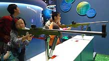 Children experience the shooting theory in the new China Science and Technology Museum in Beijing, capital of China, September 20, 2009. The Hi-tech and newly-built museum covering an area of 48,000 square meters was opened to the public on Sunday.