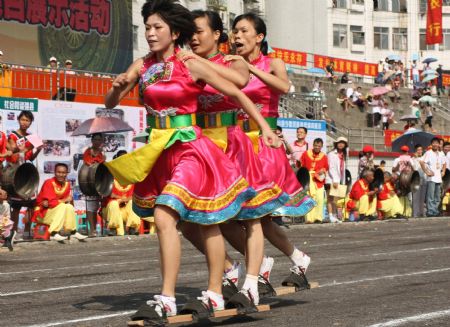 Contestants take part in the triplet bound plank shoes walking race to mark the forthcoming grand celebration of the 60th anniversary of the founding of the People's Republic of China, at Hechi City, southwest China's Guangxi Zhuang Autonomous Region, September 19, 2009. 