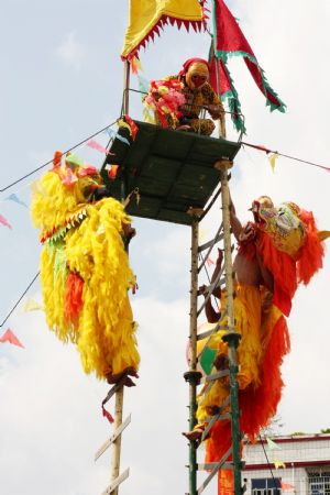 Performers stage the stunt show of dancing lions climbing onto ladder of daggers to mark the forthcoming grand celebration of the 60th anniversary of the founding of the People's Republic of China, at Hechi City, southwest China's Guangxi Zhuang Autonomous Region, September 19, 2009.