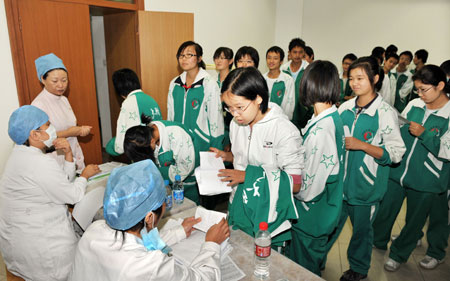 Students from the High School affiliated to Minzu University of China prepare to receive the A/H1N1 flu vaccinations in Beijing, capital of China, on September 21, 2009. 