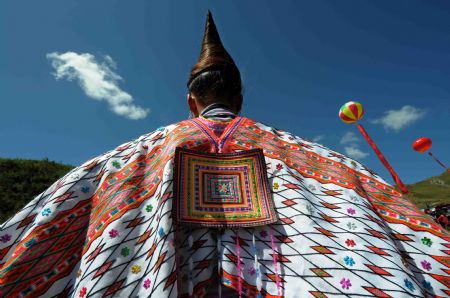 A woman of the Miao ethnic group shows up her cloak during the opening ceremony of a leek flower cultural festival held in Hezhang, southwest China's Guizhou Province, September 22, 2009. The festival opened on Tuesday in Hezhang county that grows wild leek plants of more than 30 square kilometers. 