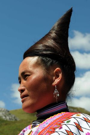 A full-dressed woman of the Miao ethnic group attends the opening ceremony of a leek flower cultural festival held in Hezhang, southwest China's Guizhou Province, September 22, 2009. The festival opened on Tuesday in Hezhang county that grows wild leek plants of more than 30 square kilometers. 