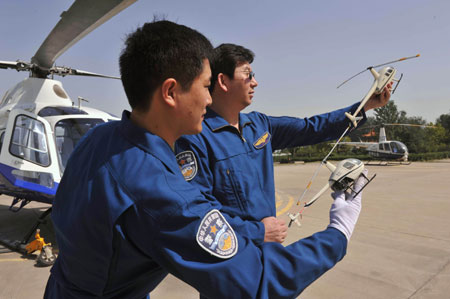 Two aviation policeman pilots demonstrate the formation in air prior to their helicopter routine patrol aviation for the tightening the orderly security guarding for the grand celebration of the National Day, in Zhengzhou, central China's Henan Province, September 23, 2009.