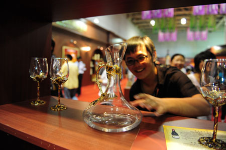 A young man reaches out for an exquisite drinking vessel during the 3rd Yantai International Wine Festival, which is set to feature series of activities including tasting and appreciating quality wine, grape-picking, fancy bartend concoction, etc, opening in Yantai, east China's Shandong Province, September 23, 2009. 