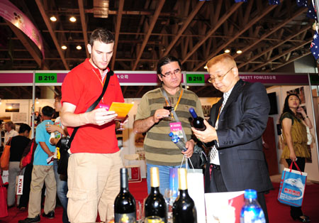 Foreign visitors learn about the local quality wine during the 3rd Yantai International Wine Festival, which is set to feature series of activities including tasting and appreciating quality wine, grape-picking, fancy bartend concoction, etc, opening in Yantai, east China's Shandong Province, September 23, 2009.