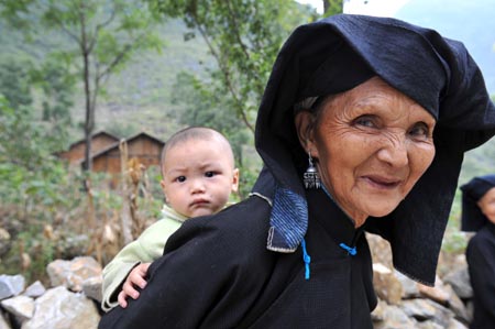 An old woman of Dark Cloth Zhuang carries her grandson on the back in Napo county, southwest China's Guangxi Zhuang Autonomous Region, September 23, 2009. 