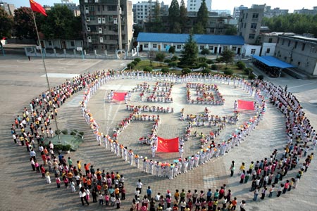 Pupils and their teachers line up in formations of heart pattern and Characters literally Long Lives to Homeland, while singing song of Ode to Homeland, on campus of Gongyuanlu Elementary School, in Zhijiang City, central China's Hubei Province, September 24, 2009. Well over 1,100 pupils and teachers gather together for a song party to express their reverence and blessings to the homeland prior to the forthcoming 60th anniversary of the founding of the People's Republic of China.