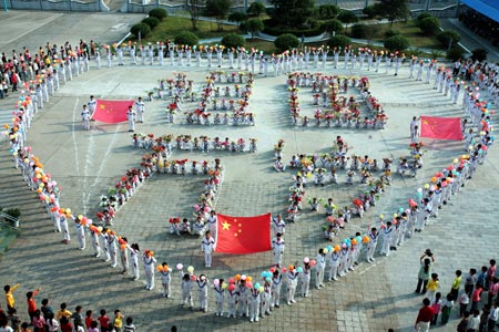 Pupils and their teachers line up in formations of heart pattern and Characters literally Long Lives to Homeland, while singing song of Ode to Homeland, on campus of Gongyuanlu Elementary School, in Zhijiang City, central China's Hubei Province, September 24, 2009. Well over 1,100 pupils and teachers gather together for a song party to express their reverence and blessings to the homeland prior to the forthcoming 60th anniversary of the founding of the People's Republic of China.