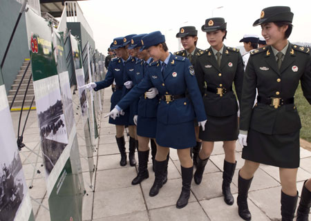 Soldiers watch photos at the Parade Photo Exhibition in Beijing, China, September 24, 2009. 