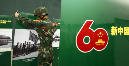 A soldier displays photos at the Parade Photo Exhibition in Beijing, China, September 24, 2009.